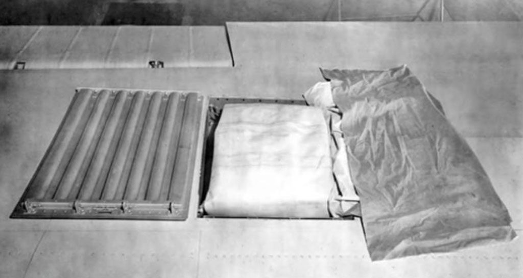 open hatch on top of a wing reveals a partially packed flotation bag